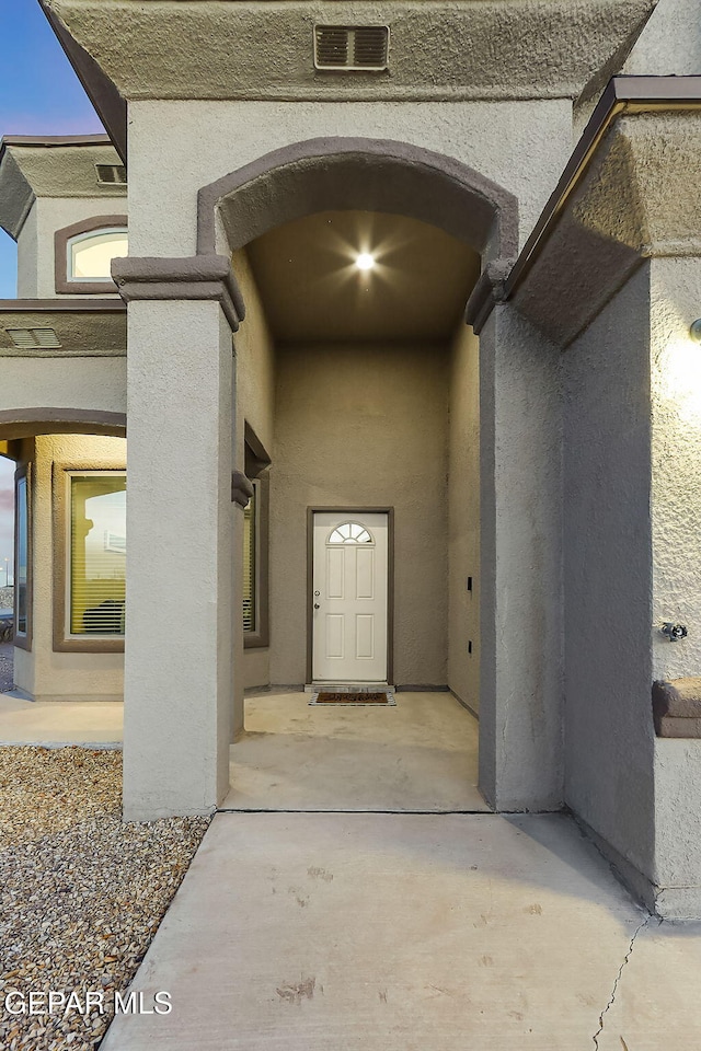 exterior entry at dusk featuring a patio area