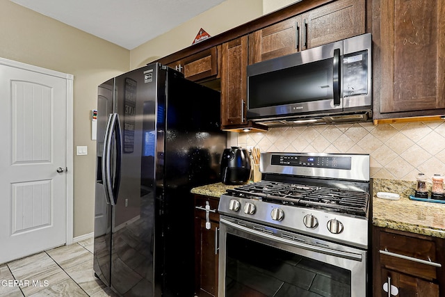 kitchen featuring light stone counters, dark brown cabinetry, appliances with stainless steel finishes, and decorative backsplash