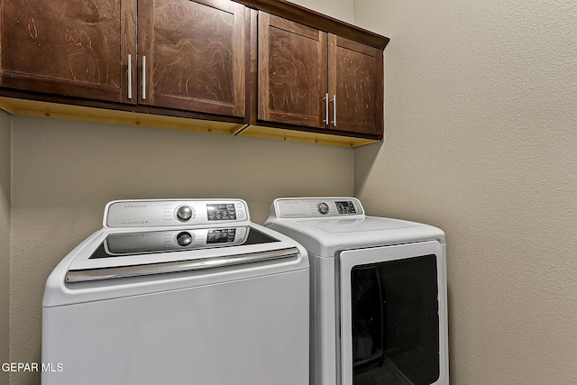 washroom with separate washer and dryer and cabinets