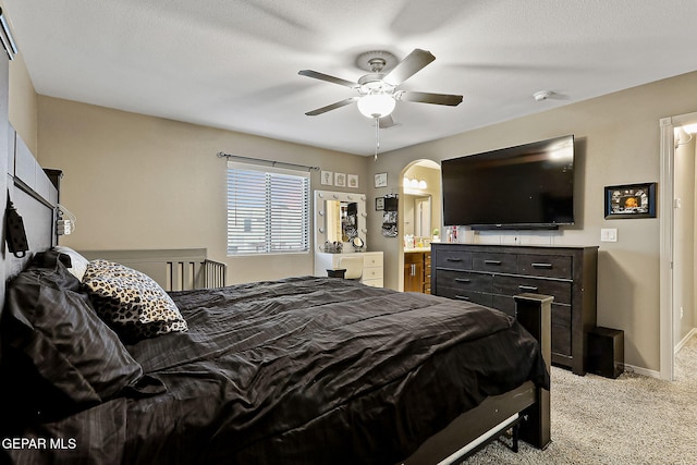 carpeted bedroom featuring ceiling fan and ensuite bathroom