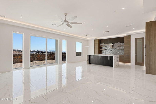 unfurnished living room featuring ceiling fan and sink