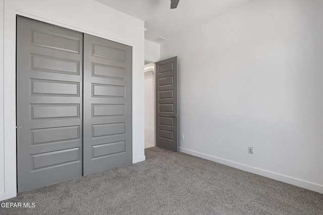 unfurnished bedroom featuring a closet, ceiling fan, and carpet