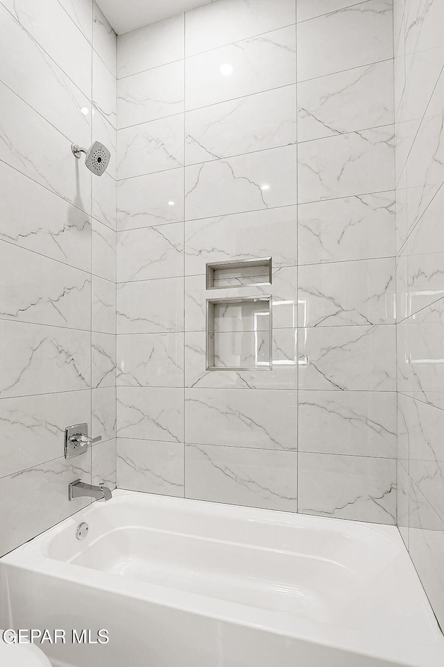 bathroom with tiled shower / bath combo