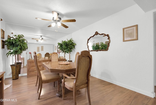 dining area with a textured ceiling, wood-type flooring, and ceiling fan