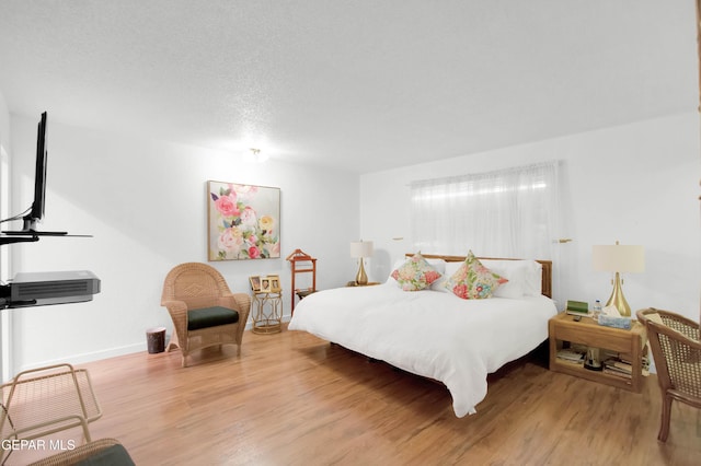 bedroom with wood-type flooring and a textured ceiling