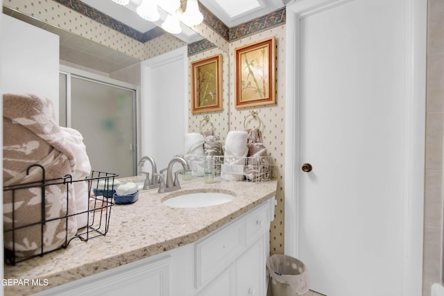 bathroom featuring a shower with door, vanity, and a skylight