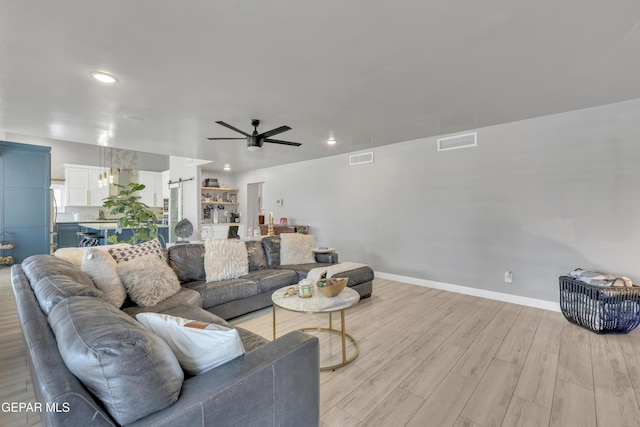 living room with ceiling fan and light wood-type flooring