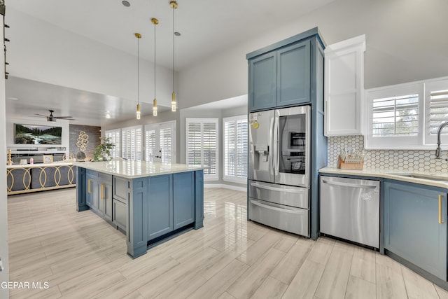 kitchen with a kitchen island, appliances with stainless steel finishes, pendant lighting, sink, and decorative backsplash