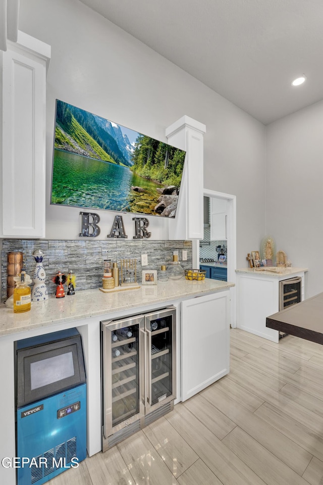 kitchen featuring white cabinetry, light stone counters, and decorative backsplash