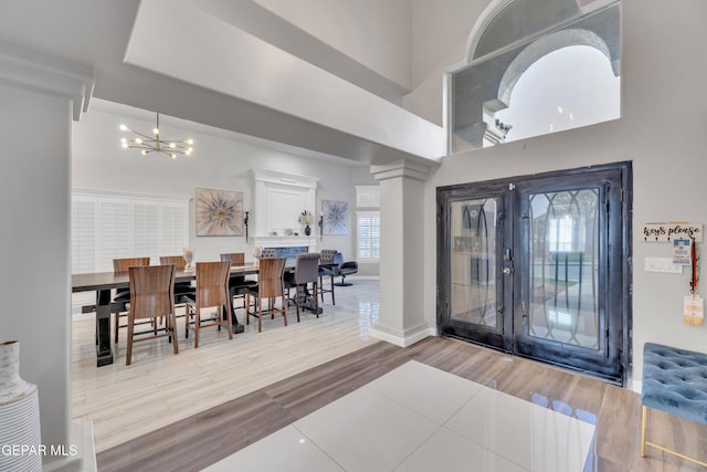 entryway featuring a high ceiling, hardwood / wood-style floors, an inviting chandelier, and french doors