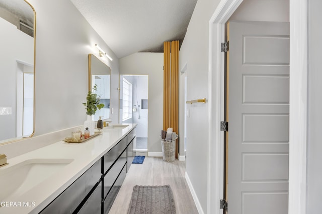 bathroom with vanity, wood-type flooring, and lofted ceiling