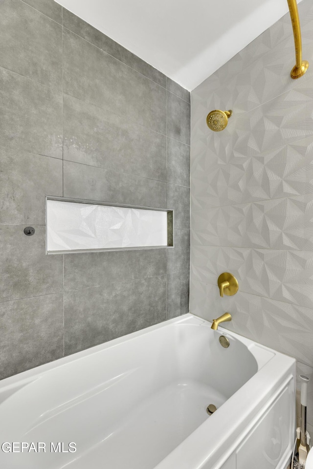 bathroom with tiled shower / bath and tile walls