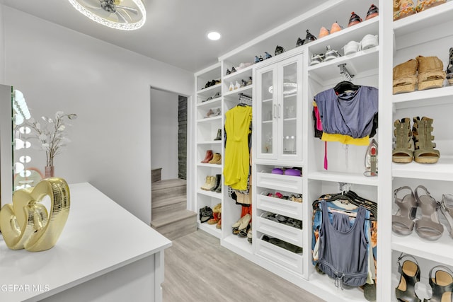 walk in closet with light hardwood / wood-style flooring