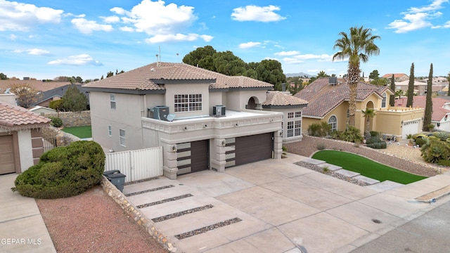 mediterranean / spanish house with a garage and central AC