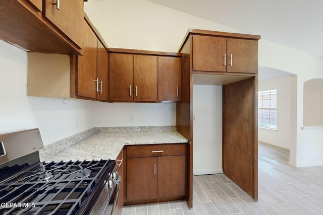 kitchen with stainless steel range with gas cooktop and light stone countertops