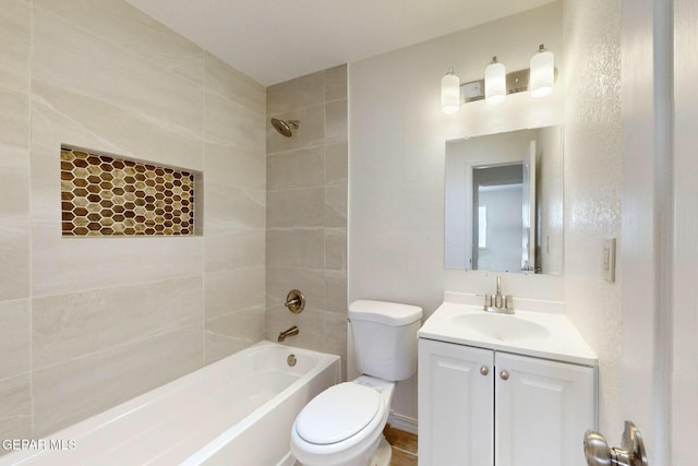 full bathroom with tiled shower / bath, vanity, and toilet