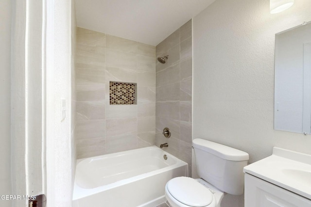 full bathroom featuring vanity, tiled shower / bath combo, and toilet