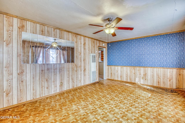 empty room featuring parquet floors, ceiling fan, crown molding, and a textured ceiling