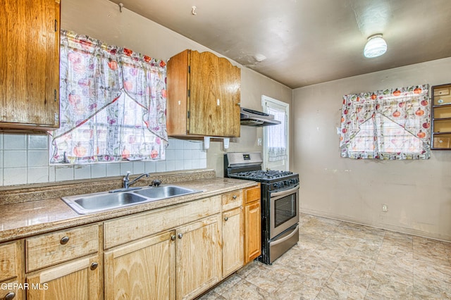 kitchen featuring tasteful backsplash, stainless steel gas range oven, and sink