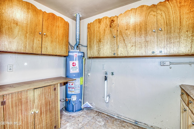 clothes washing area featuring cabinets, hookup for a washing machine, and water heater