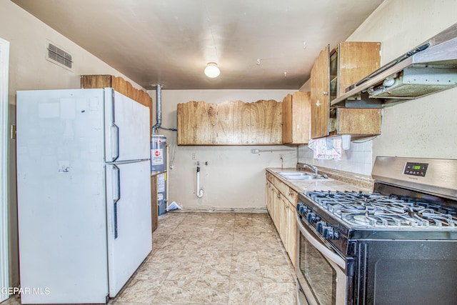 kitchen featuring sink, gas range, white refrigerator, backsplash, and exhaust hood