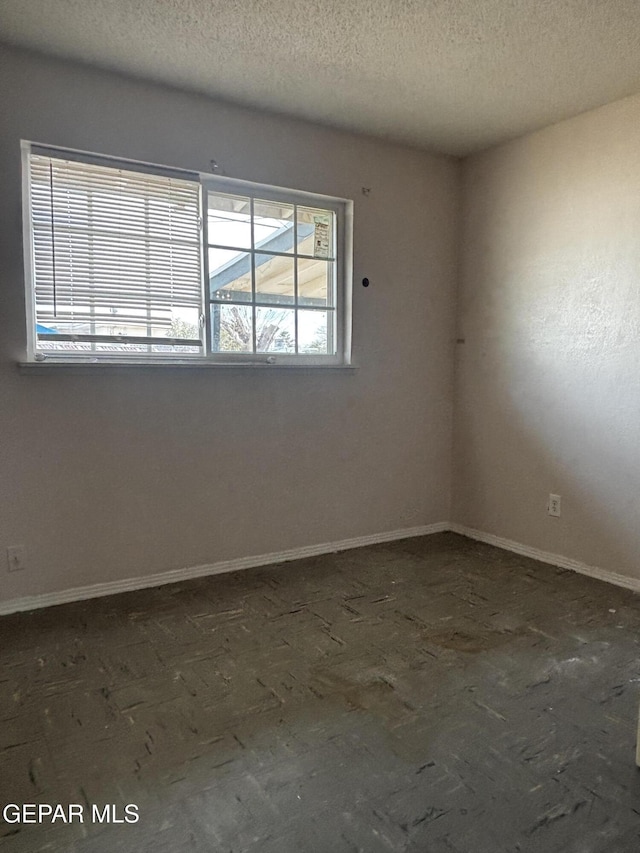 unfurnished room with a textured ceiling