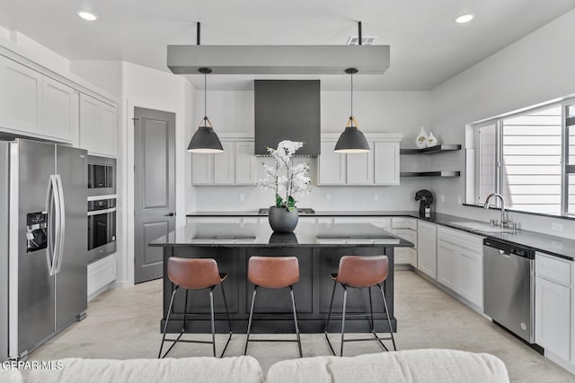 kitchen featuring sink, decorative light fixtures, stainless steel appliances, and a kitchen island