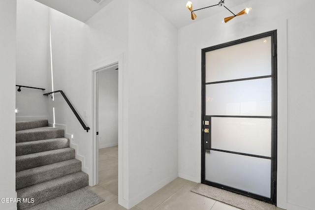 foyer featuring an inviting chandelier and light tile patterned floors