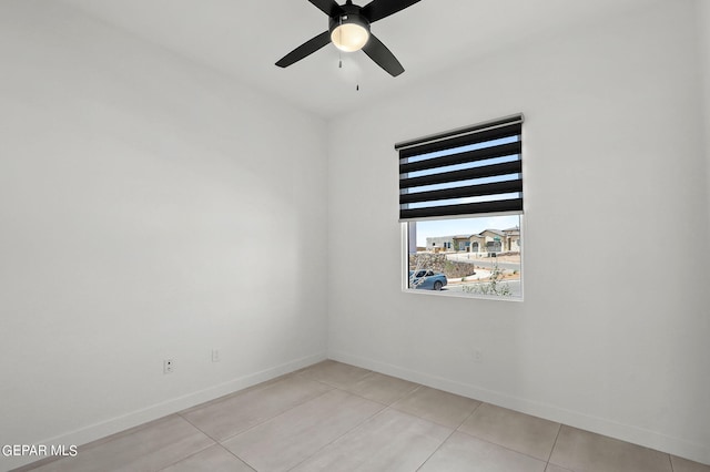 tiled spare room featuring ceiling fan