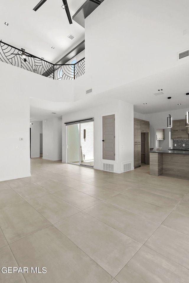 tiled spare room with a high ceiling