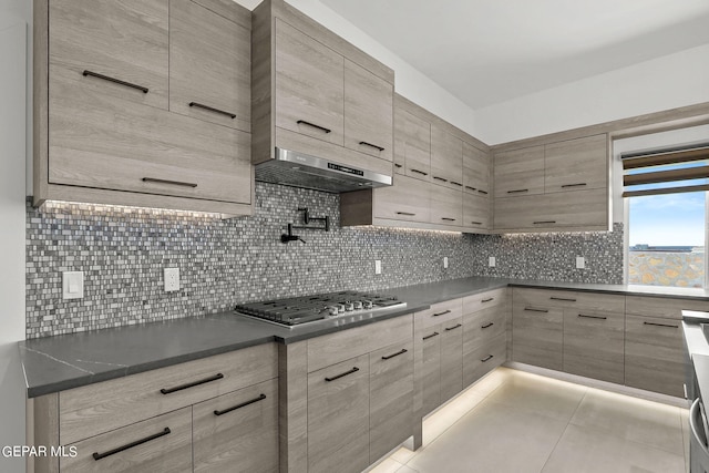 kitchen with tasteful backsplash, stainless steel gas cooktop, and light tile patterned floors