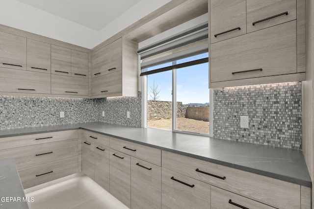 kitchen with tasteful backsplash and light brown cabinets