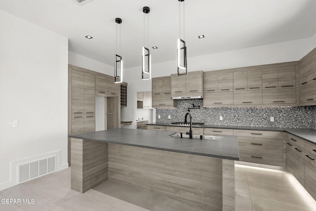 kitchen with sink, light tile patterned floors, gas cooktop, decorative backsplash, and decorative light fixtures