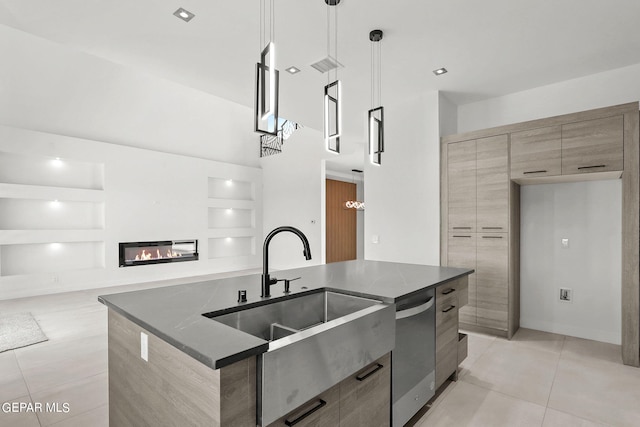 kitchen featuring decorative light fixtures, dishwasher, sink, light tile patterned floors, and a center island with sink