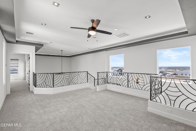 carpeted empty room featuring a wealth of natural light and ceiling fan