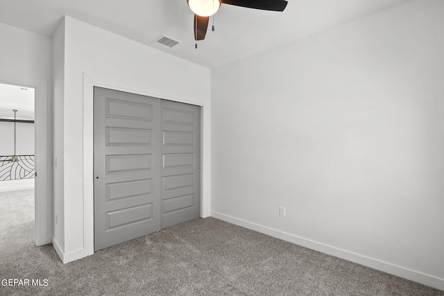 unfurnished bedroom with carpet floors, a closet, and ceiling fan