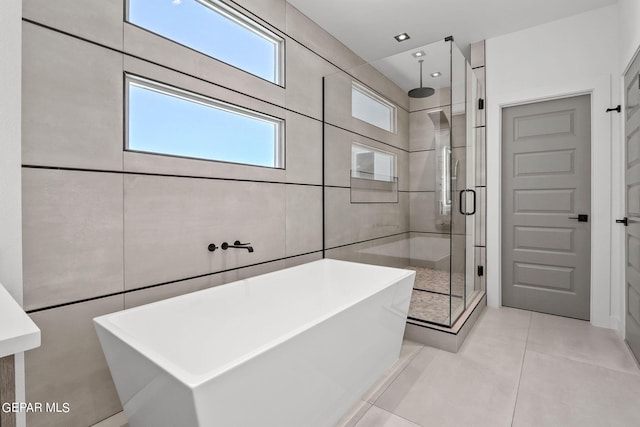 bathroom featuring tile walls, tile patterned floors, and shower with separate bathtub