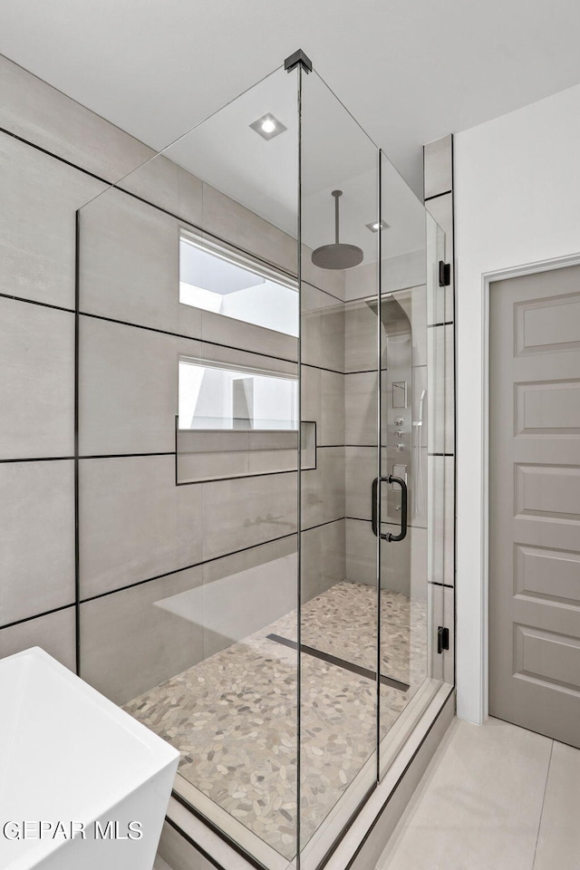 bathroom featuring tile patterned flooring and independent shower and bath