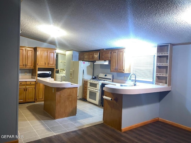 kitchen featuring sink, light hardwood / wood-style flooring, double oven range, a kitchen island, and white fridge with ice dispenser