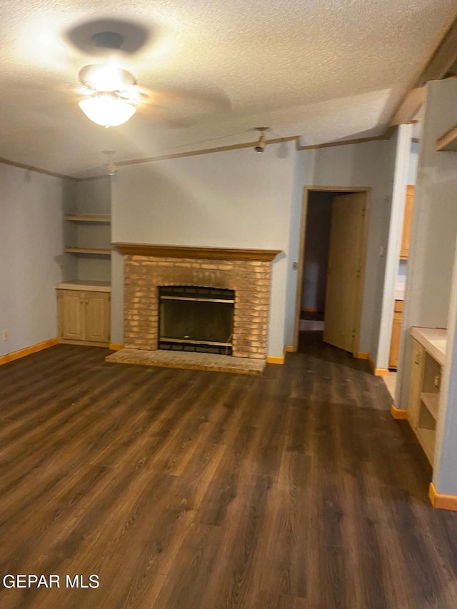 unfurnished living room with lofted ceiling, dark wood-type flooring, a textured ceiling, and a fireplace