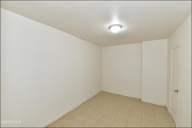 unfurnished room with a textured ceiling