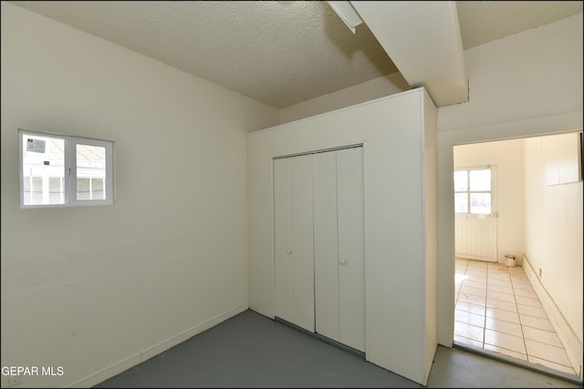 unfurnished bedroom with a closet and a textured ceiling