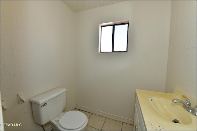 bathroom with tile patterned floors, vanity, toilet, and a textured ceiling