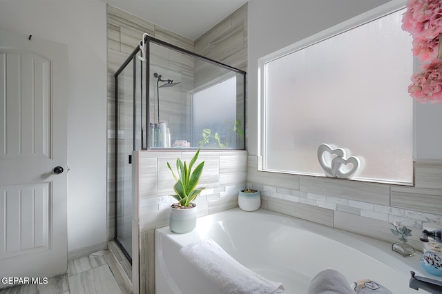 bathroom featuring separate shower and tub