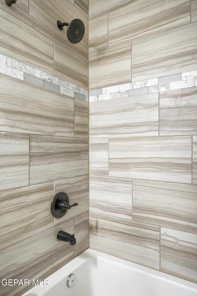 interior details with tiled shower / bath combo