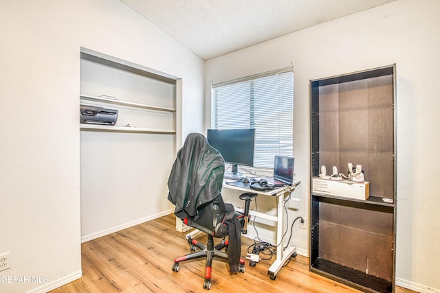 office space with wood-type flooring, lofted ceiling, and a textured ceiling