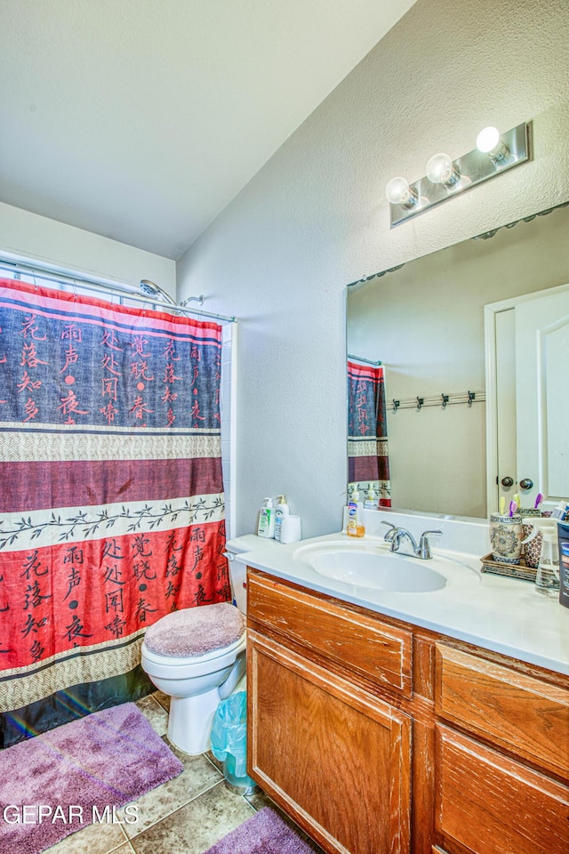 bathroom with vanity, vaulted ceiling, a shower with shower curtain, and toilet