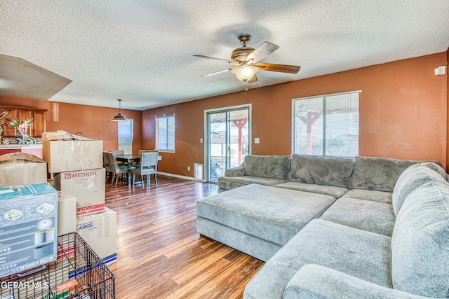 living room featuring hardwood / wood-style floors, a textured ceiling, and ceiling fan