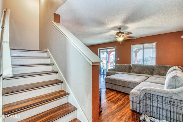 staircase featuring hardwood / wood-style floors, a textured ceiling, and ceiling fan