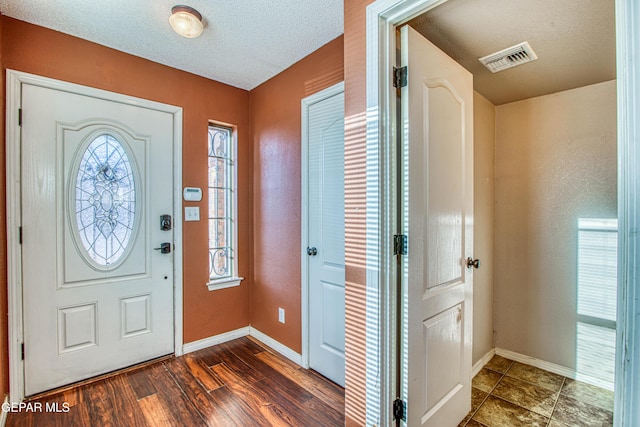 entryway with a textured ceiling and dark hardwood / wood-style flooring